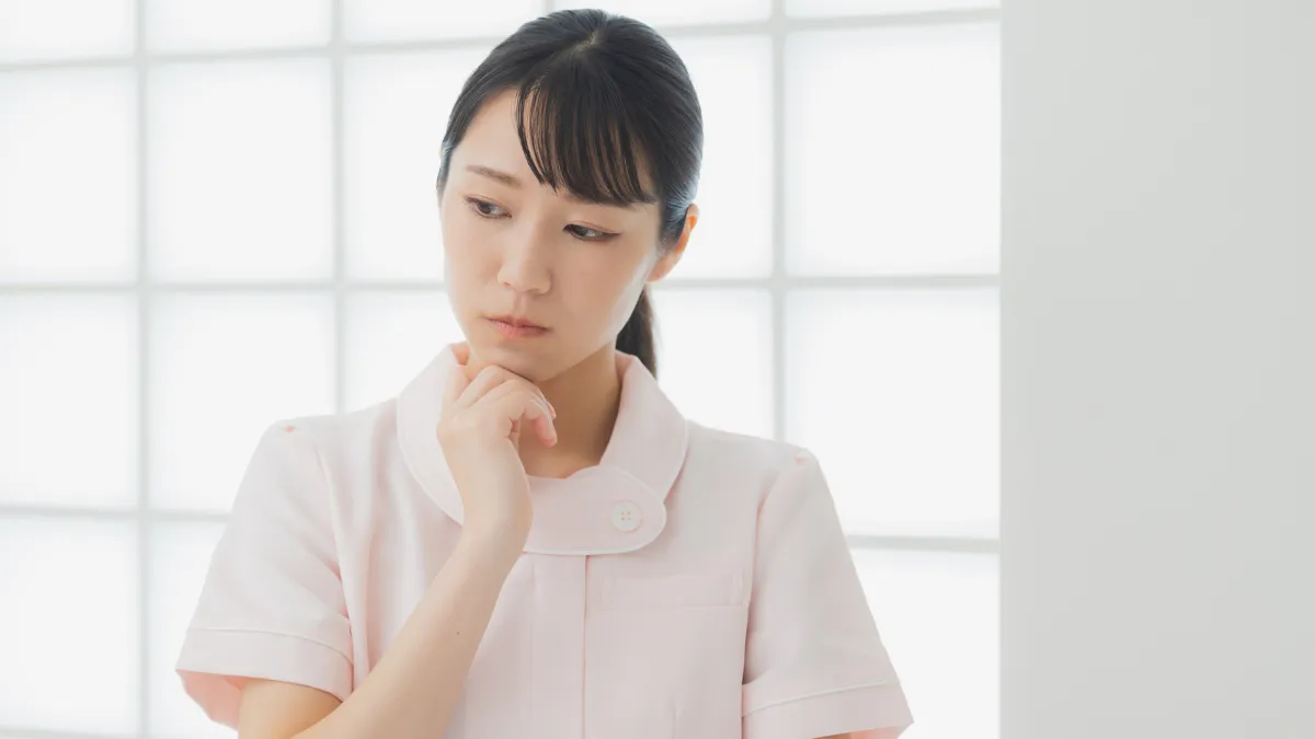 白衣を着た女性が悩んでいる