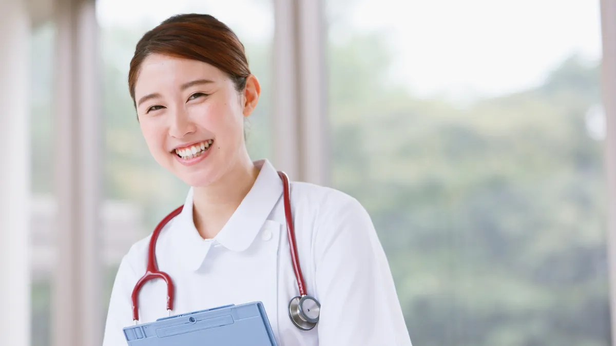 白衣の女性が笑顔で笑っている