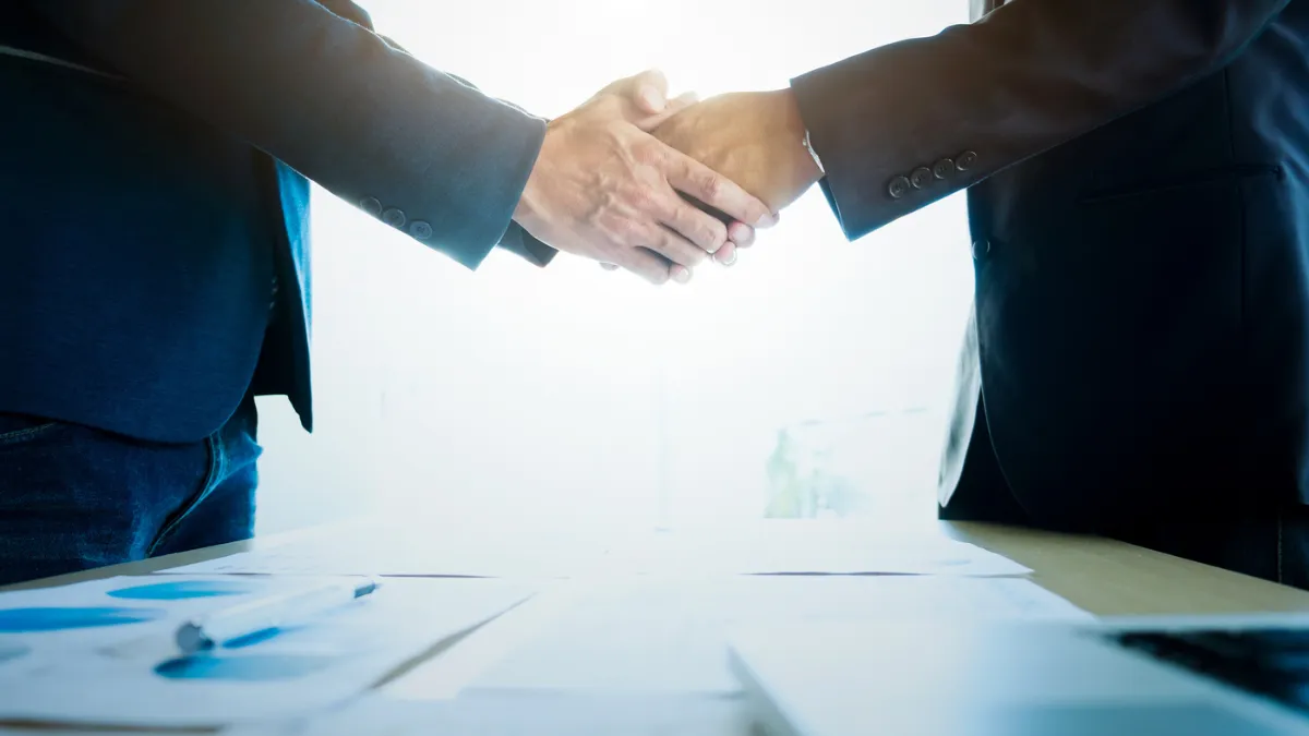 スーツを着た人たちが握手してる