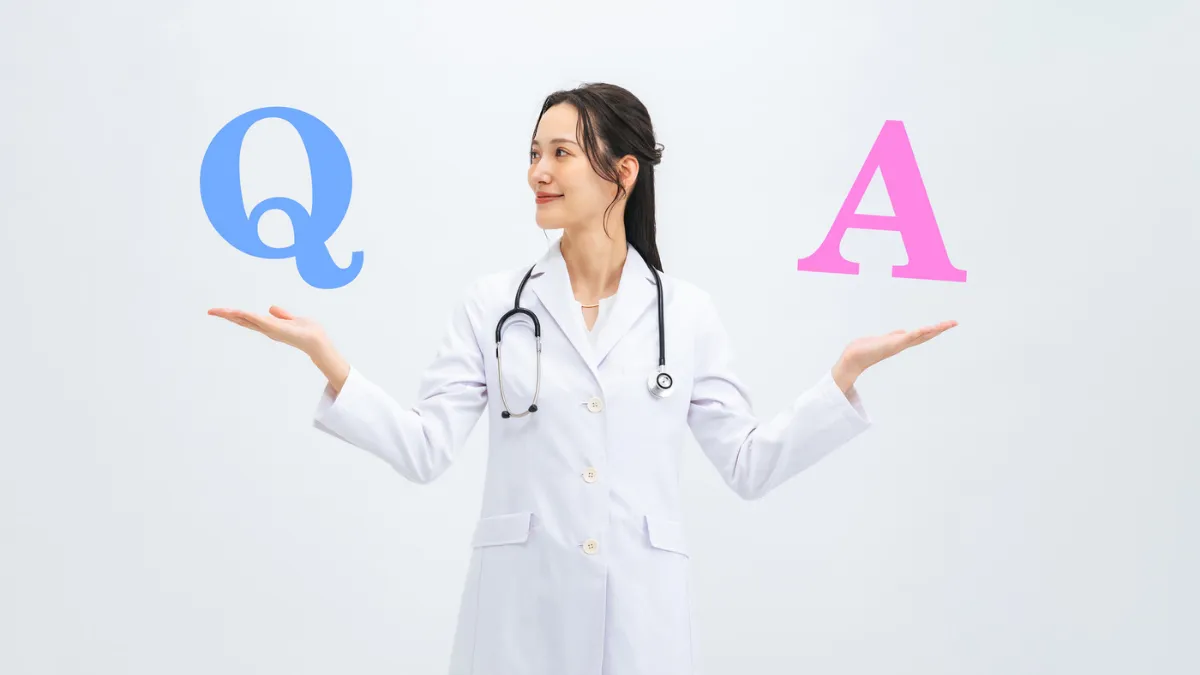 白衣を着た女性がQとAの文字を両手に浮かせている