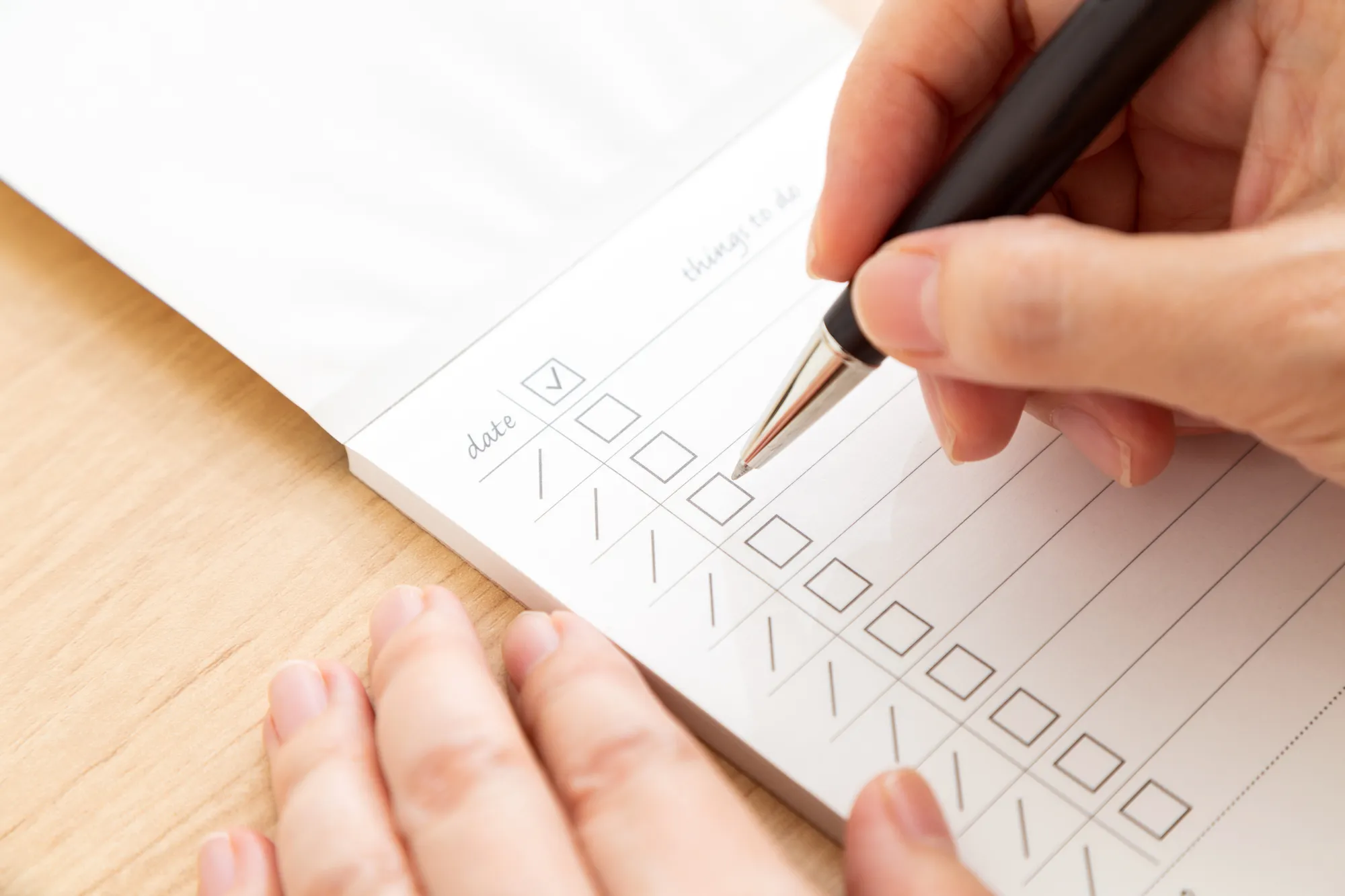 ペンを持った人が紙にチックをつけている