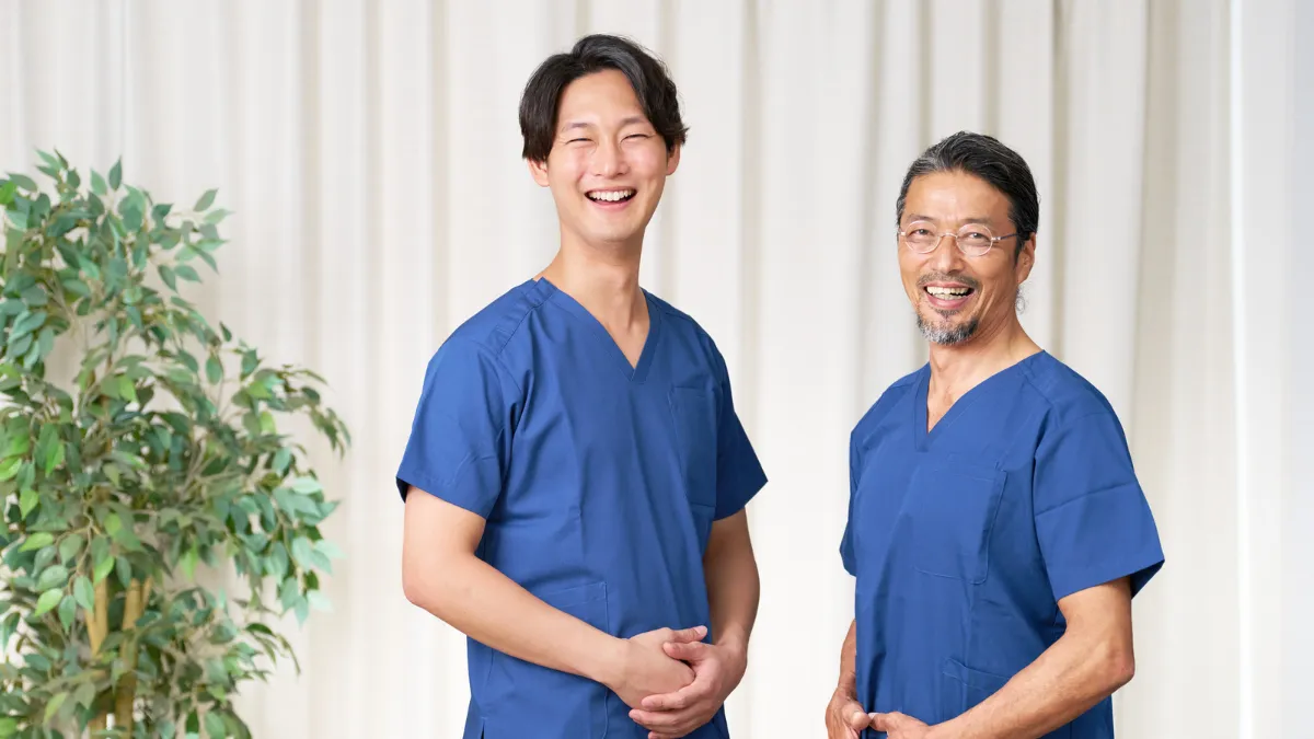 スクラブを着た男性2人が笑顔でこちらを見ている
