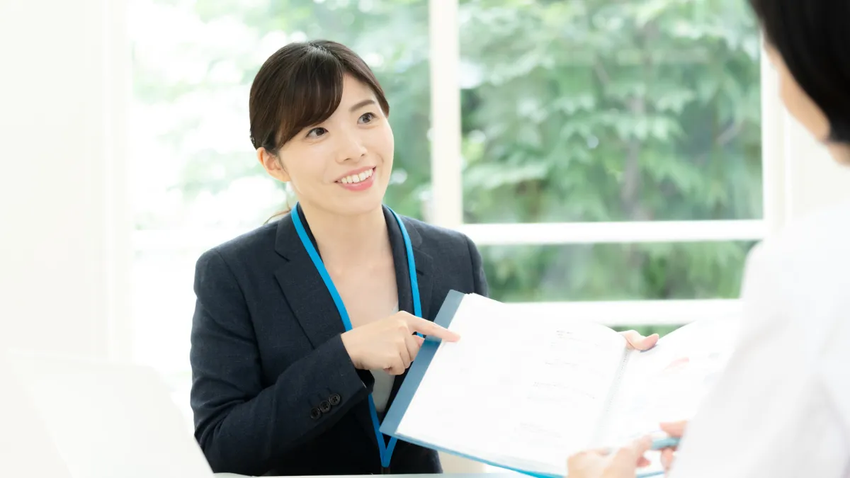 スーツの女性がファールを持って説明している