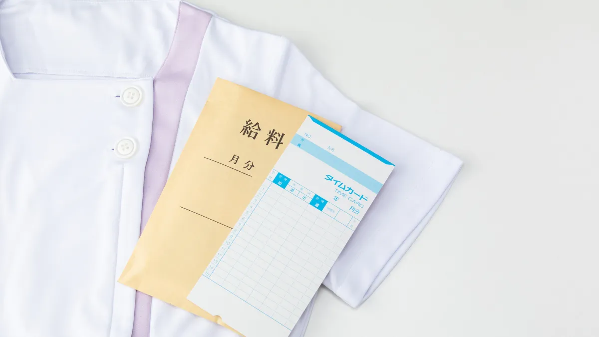 白衣の上に給料袋が乗っている