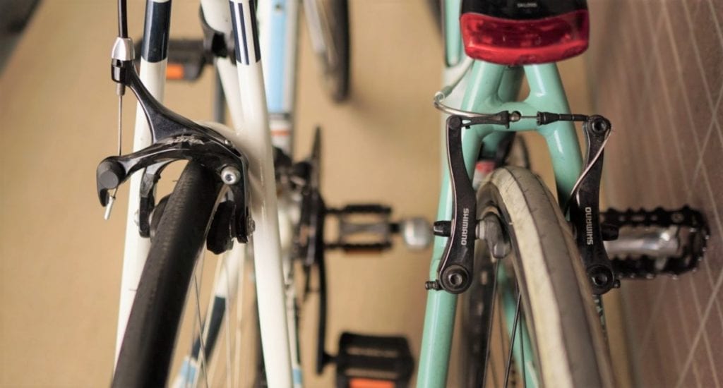 フラットバーロードのキャリパーブレーキ(左)と、クロスバイクのVブレーキ(右)