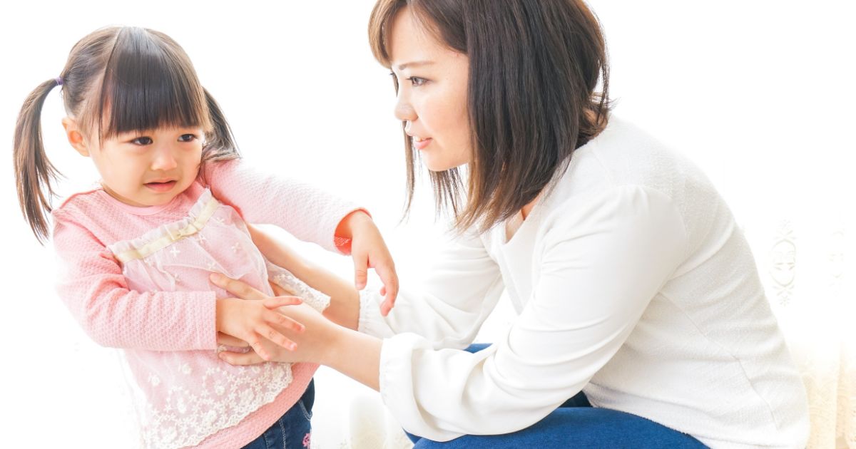 ぐずる子どもを諭す親