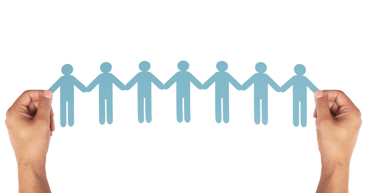 手を繋いだ人々を模したオブジェを持つ手