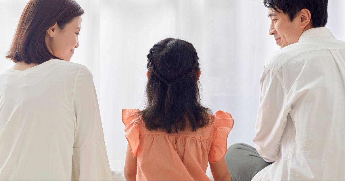 子どもを真ん中に座る、両親