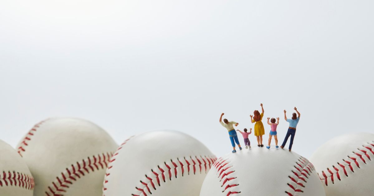 野球ボールの上にいる家族のミニチュア