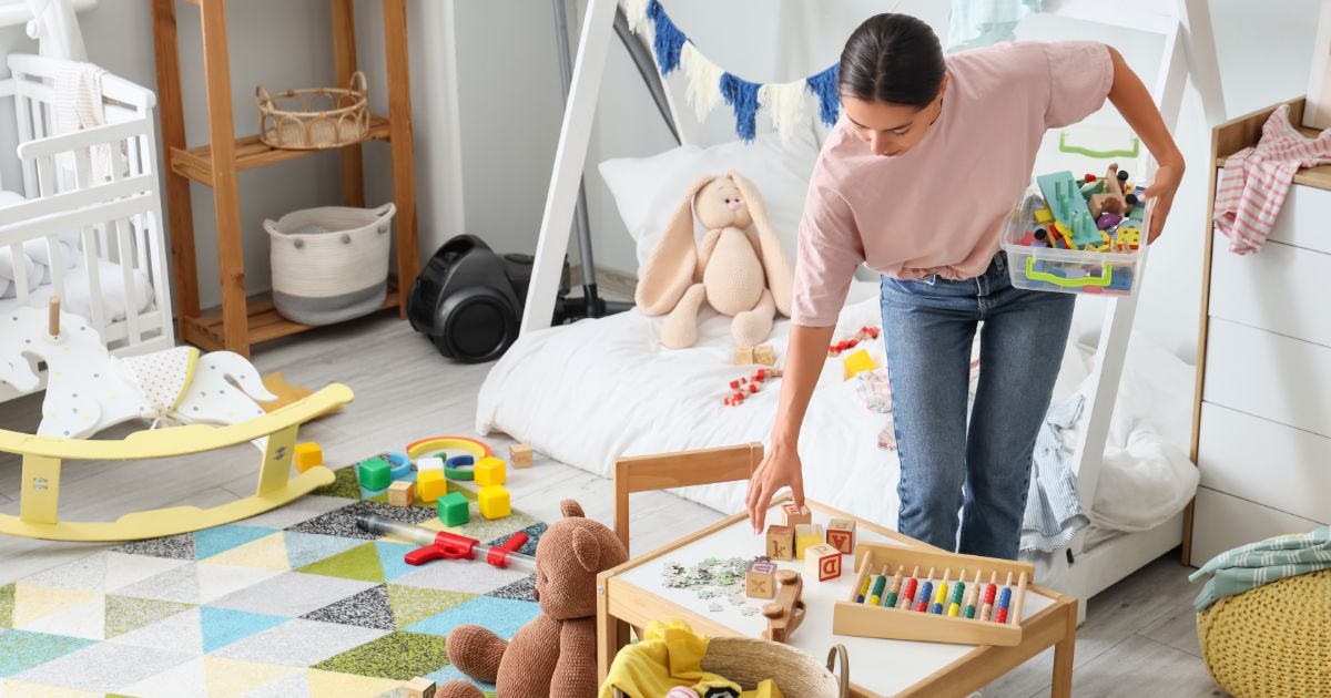 散らかった子ども部屋を片付ける母親