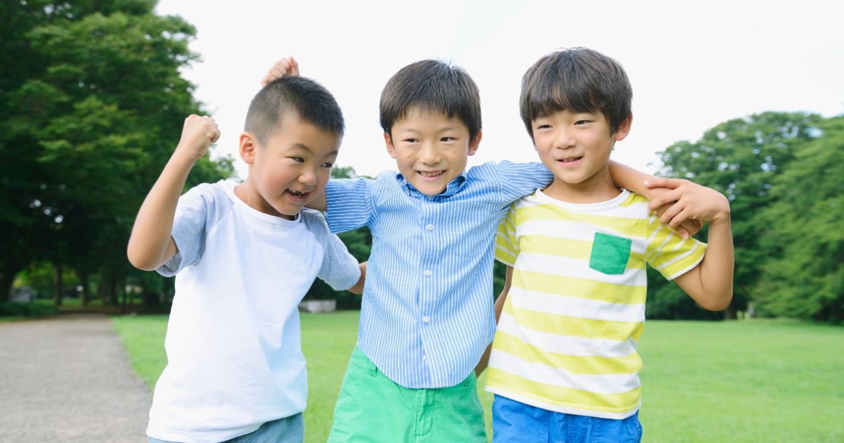 3人の男の子が肩を組んでいる