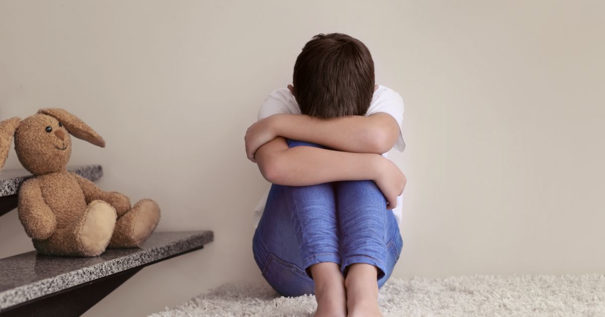 子どもが膝を抱えて泣いている