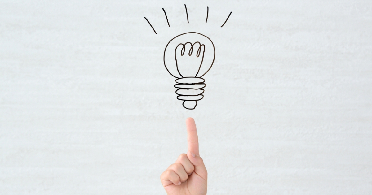 指先の上に、ひらめきを表す電球のイラストが描かれている