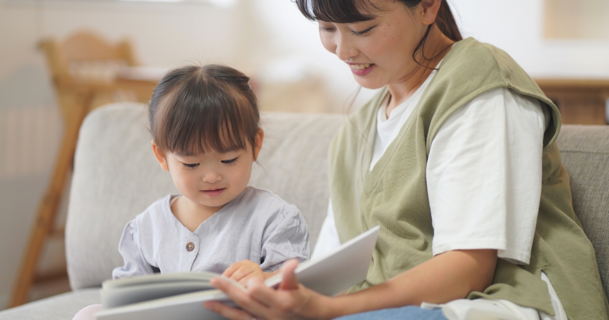 母と娘がソファで読書をしている様子