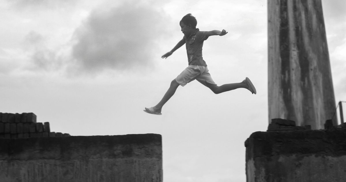 高いところをジャンプしている少年