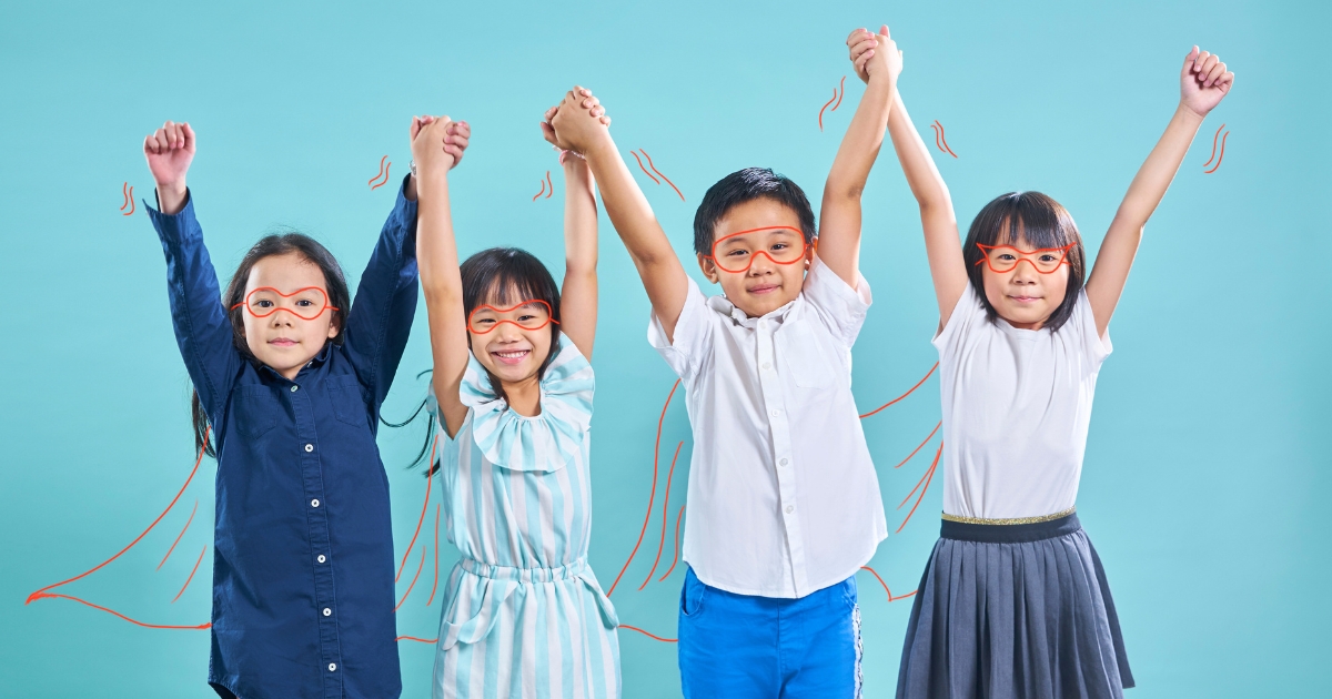 青い背景の前で、4人の子どもが両手を高く上げて並び、オレンジ色の手描き風イラストでメガネやマントが描き足された、ヒーローのような雰囲気
