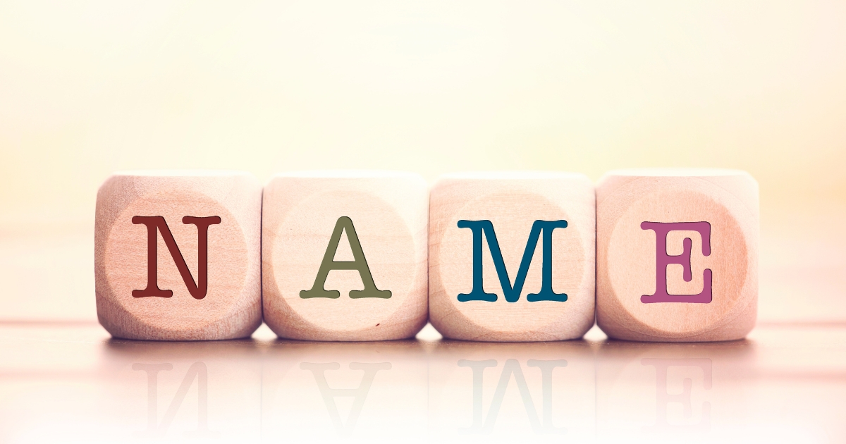 「NAME」のアルファベットが1文字ずつプリントされた4つの木製キューブ