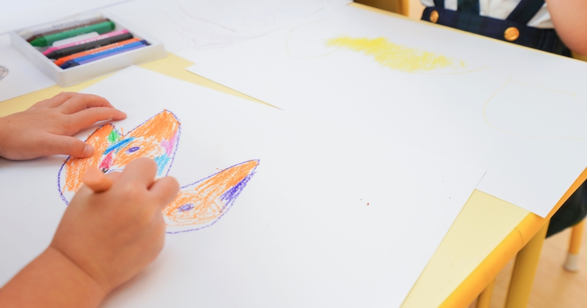 クレヨンでカラフルな絵を描くこどもたち