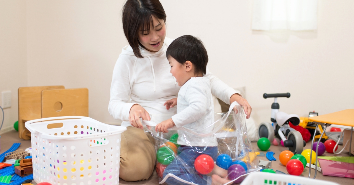 に散らかったおもちゃを、夕食前や就寝前に子どもと一緒にゲーム感覚で片付ける様子