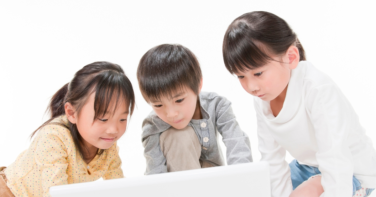 3人の子どもがノートパソコンの画面をのぞき込んでいる様子