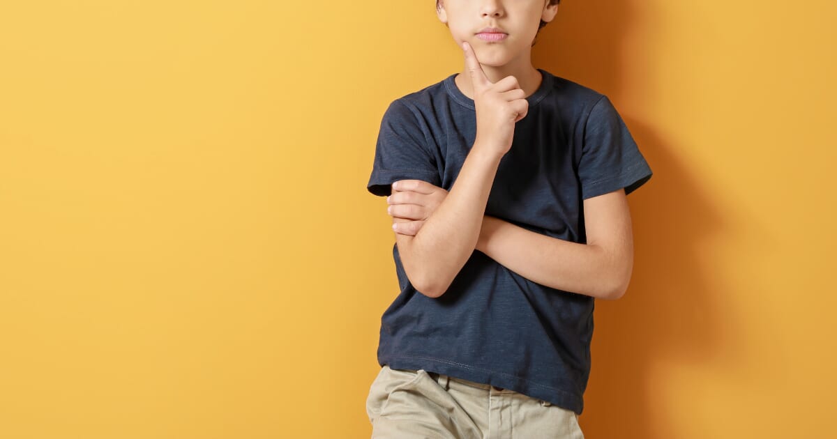 あごに手をあてて考え込む男の子