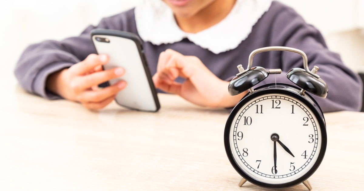 SNSを眺める子どもとスマホ利用時間を意識させる目覚まし時計