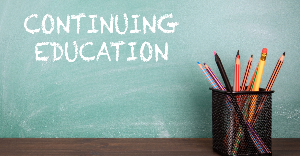 黒板に書かれた「CONTINUING EDUCATION」の文字とペン立てに入った色鉛筆
