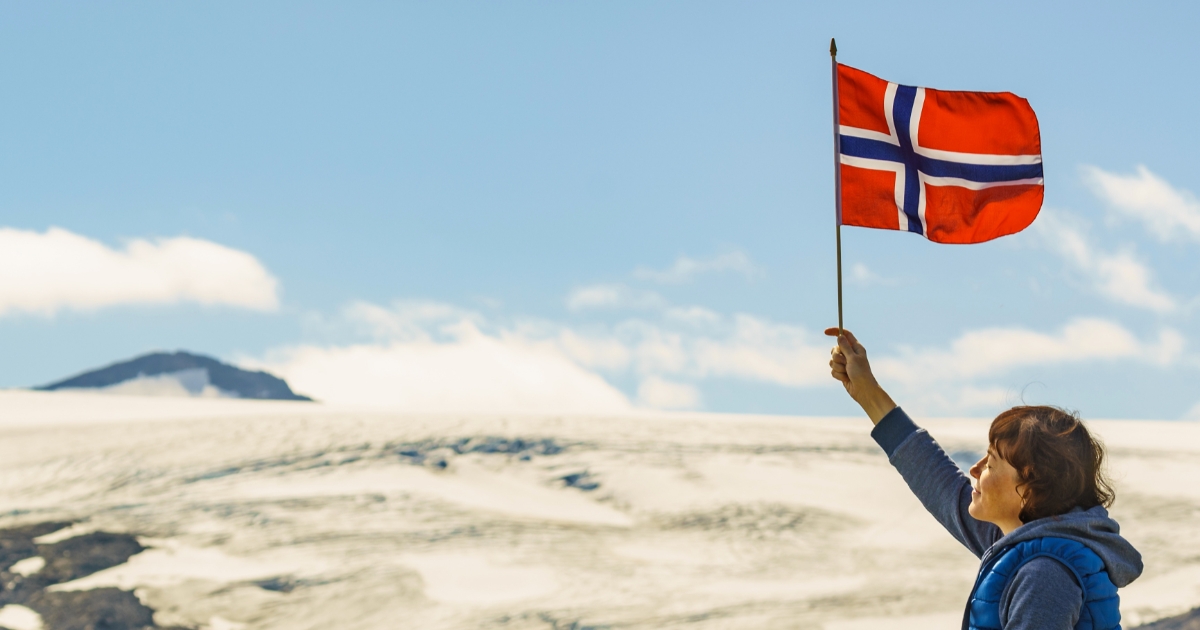ノルウェーの国旗を持って上を見上げる人物