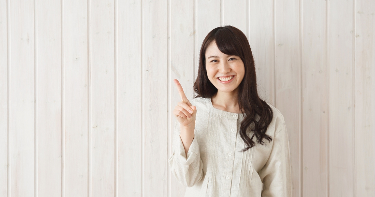 笑顔で人差し指を立てる女性