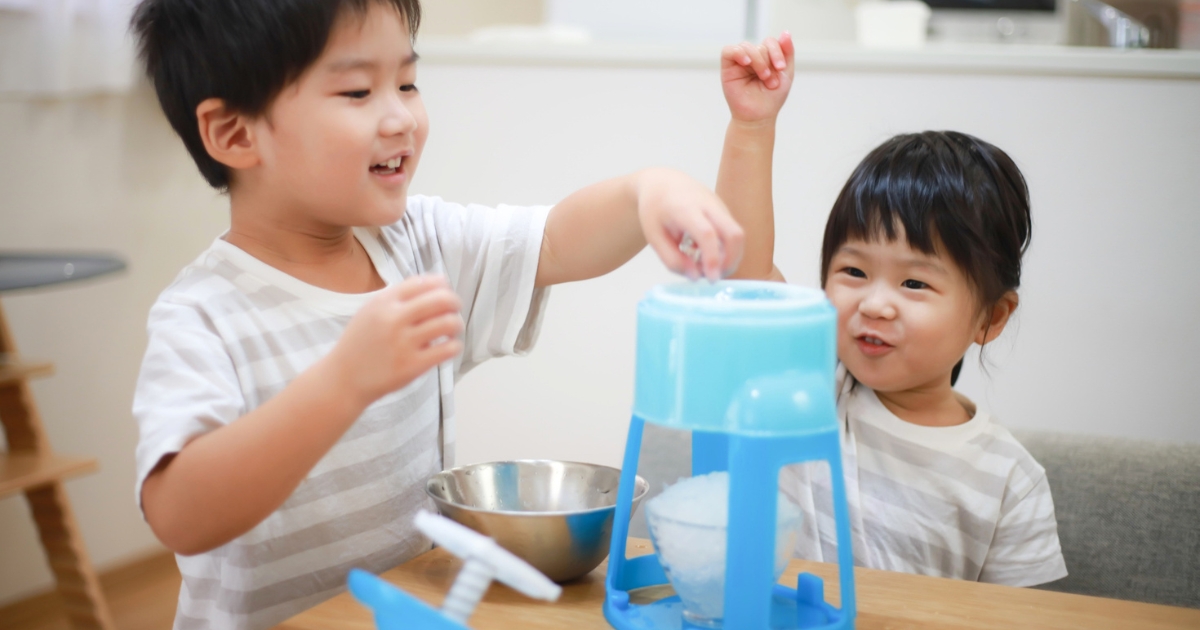 家庭用かき氷機で楽しそうにかき氷をつくる男の子と女の子