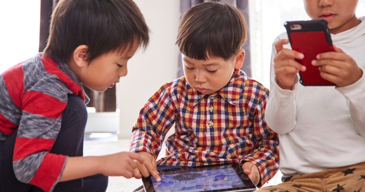 子ども3人がタブレットやスマホを使っている様子