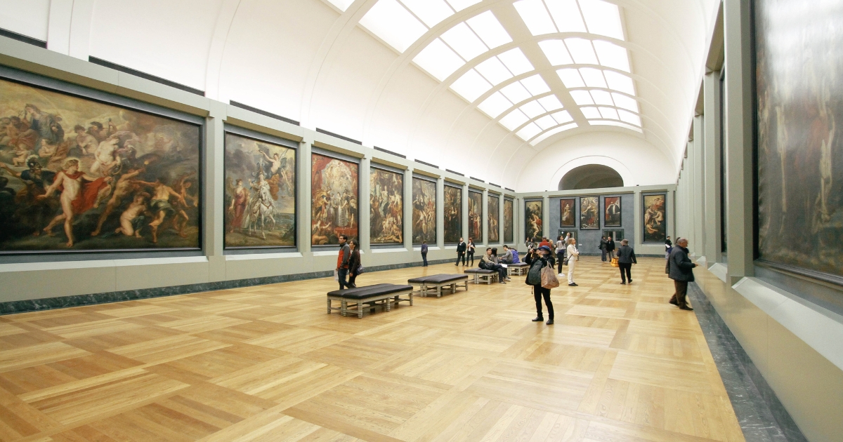 美術館で人々が絵の展示を観賞している様子