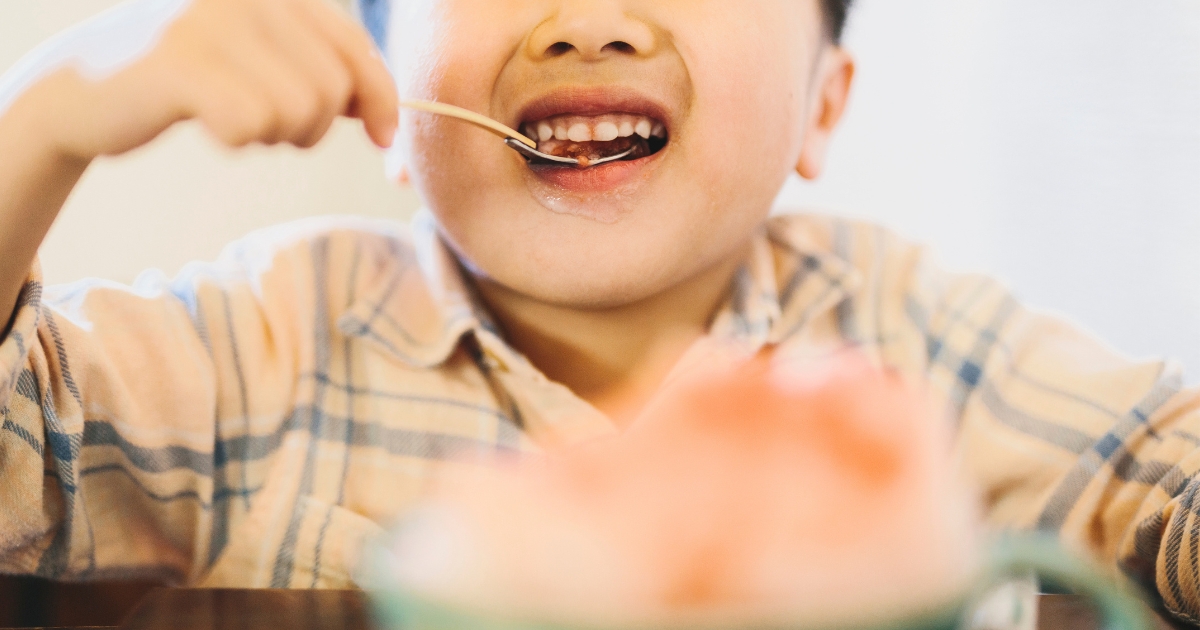 かき氷をスプーンで口に運んで食べる男の子の口元
