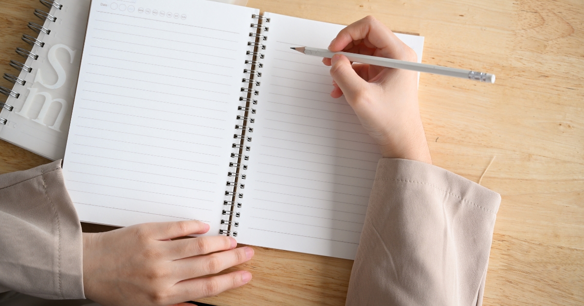 ノートとペンでテキストを書く様子