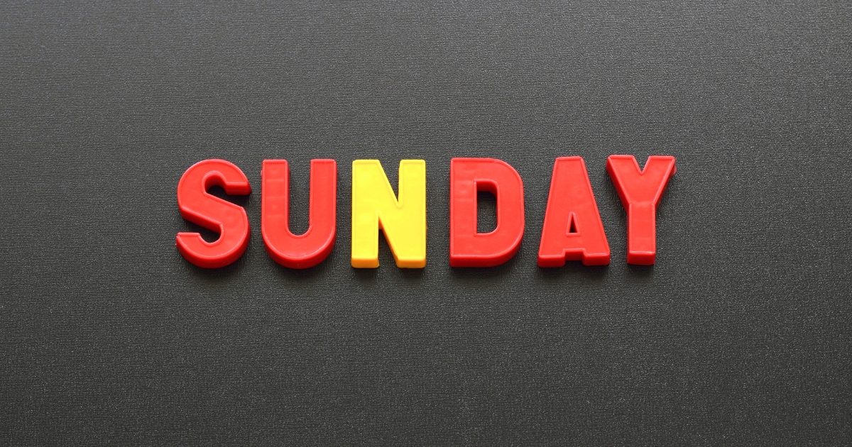 黒背景にSUNDAYの文字。Nが黄色、そのほかの文字が赤い色