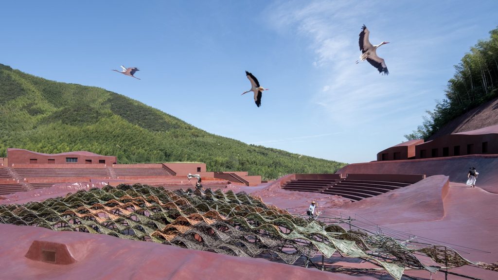 Birds flying across the open-air auditorium