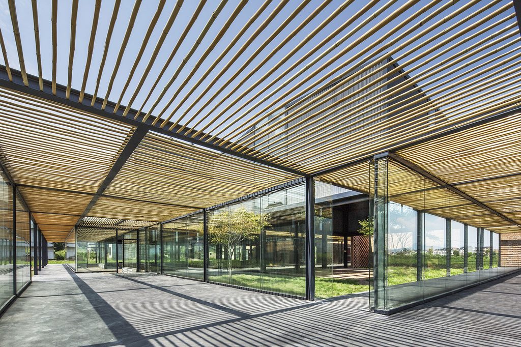 Bamboo slats above a steel-framed walkway beside the glazed rooms