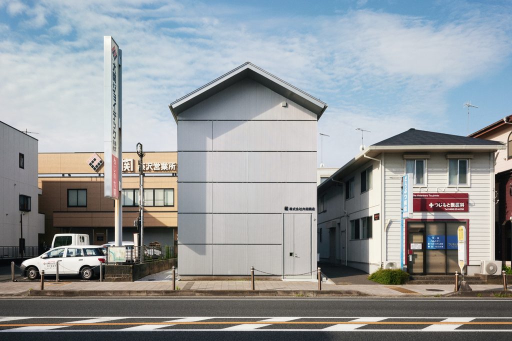The narrow building between its neighbours, windows shut