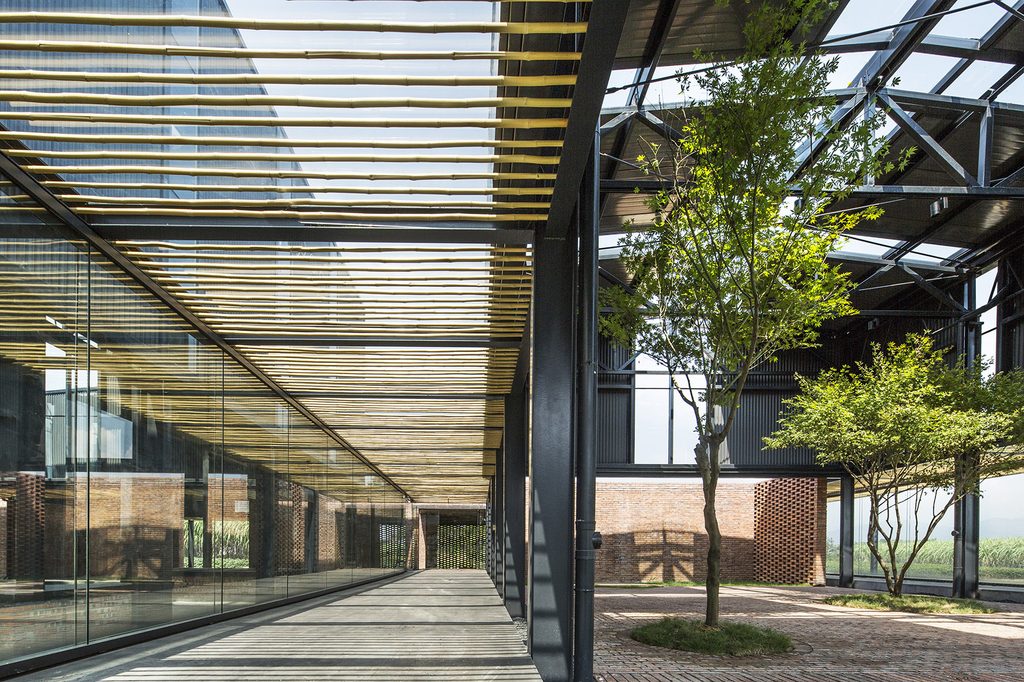Steel columns and bamboo screens beside trees in the courtyard