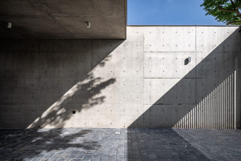 Sunlight and shadow across a concrete wall