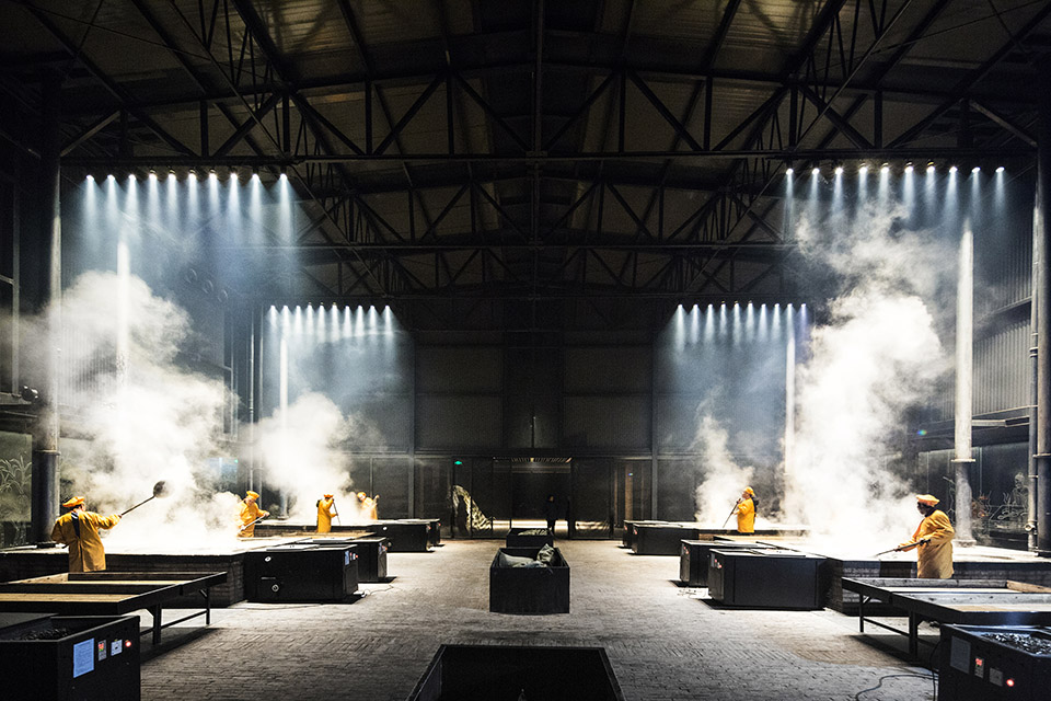 Steam rising from stoves across the dark production hall