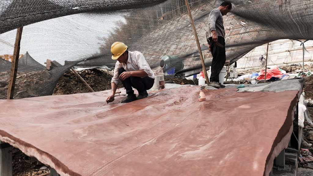 Workers finishing the sculpted concrete surface