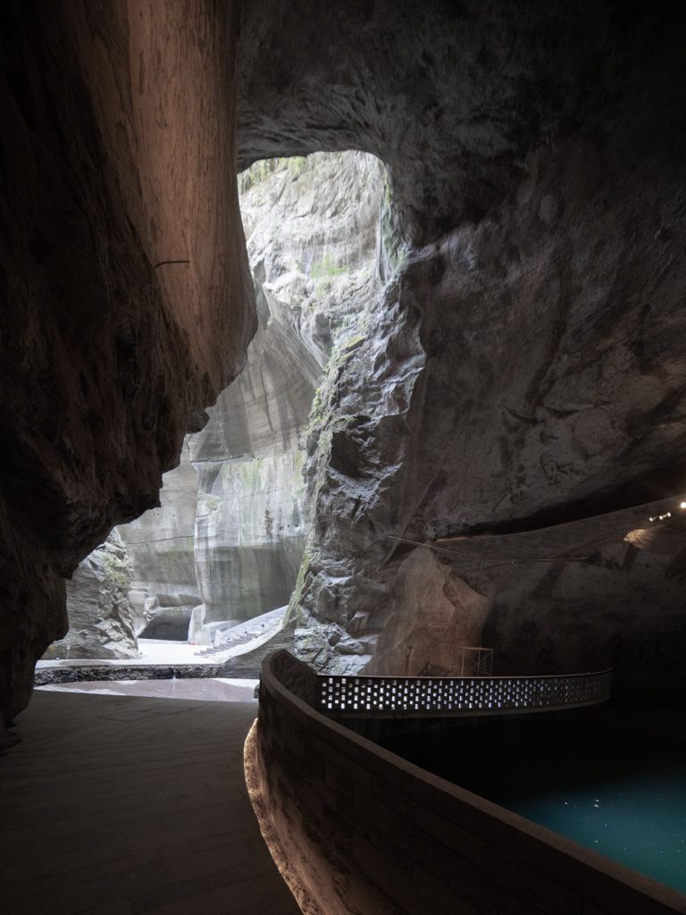 Curved walkway leading toward a daylight opening