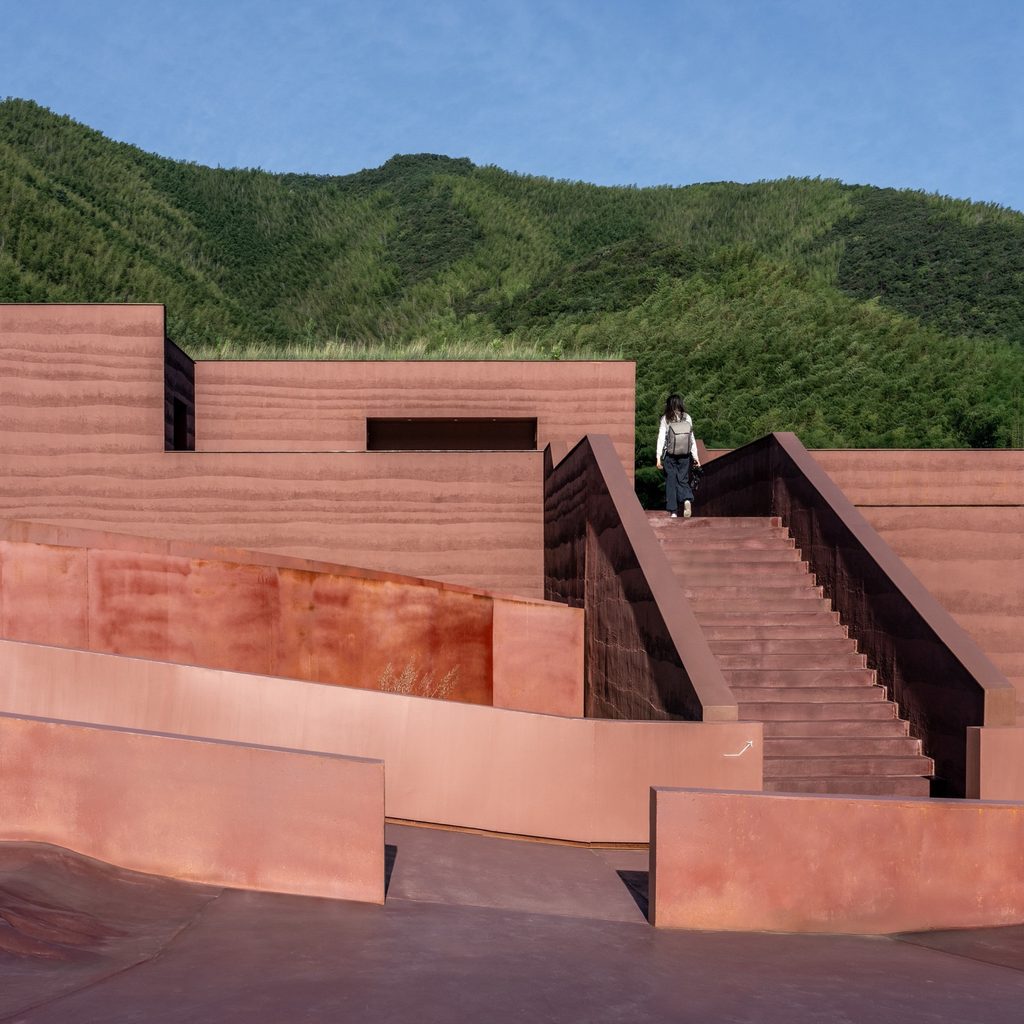 Concrete stair between textured red walls