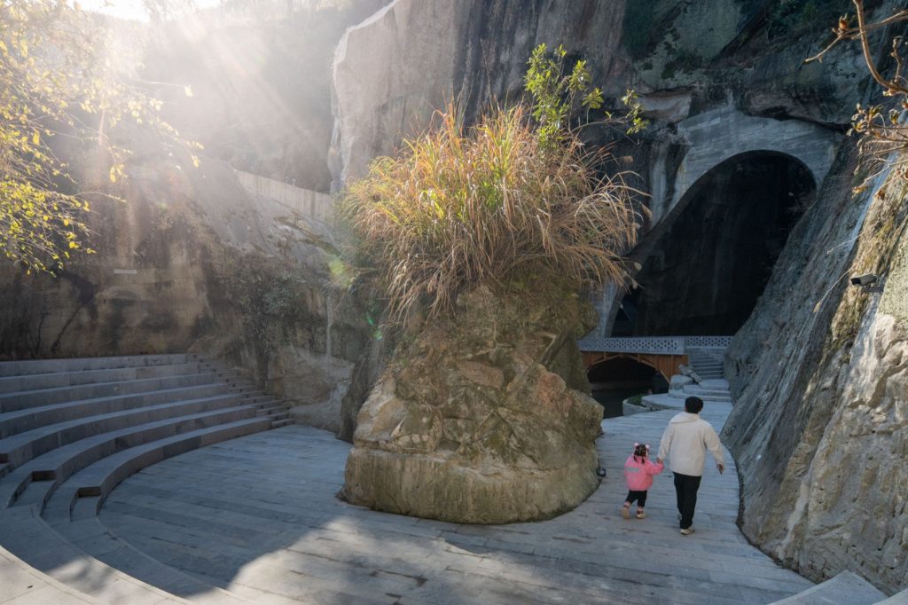 Visitors walking beside outdoor theater seating
