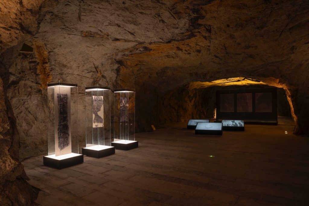 Illuminated glass cases within a stone chamber