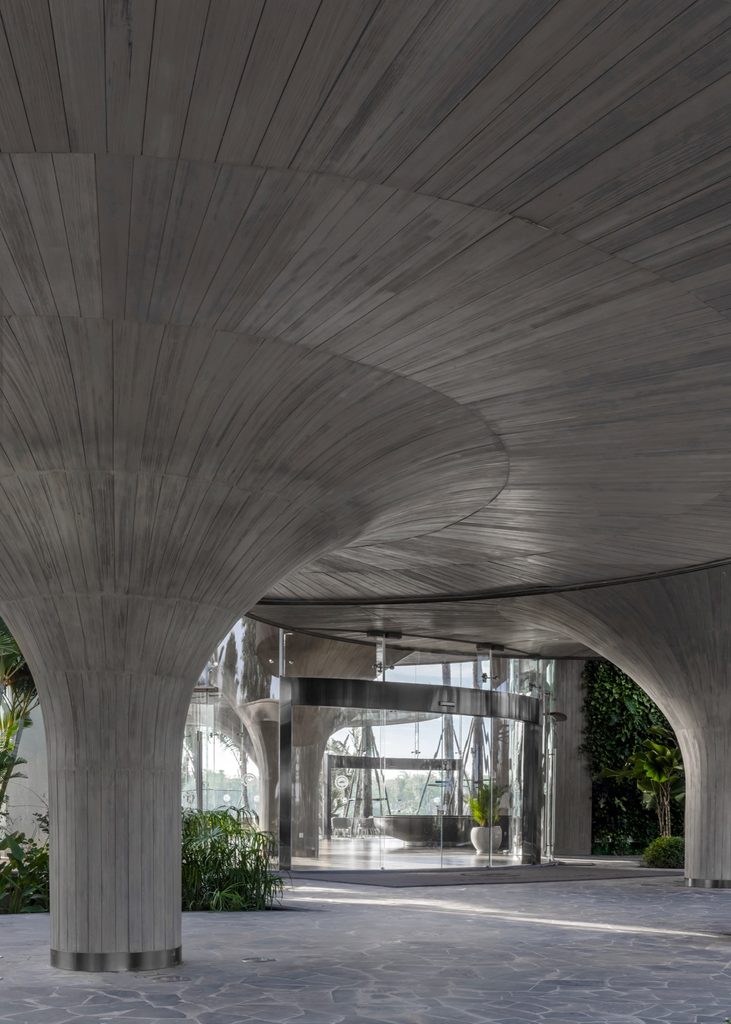 Entrance beneath a flared concrete column and curved roof
