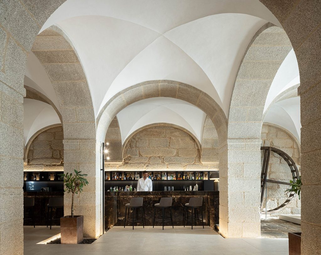 Hotel bar beneath stone arches and white vaults