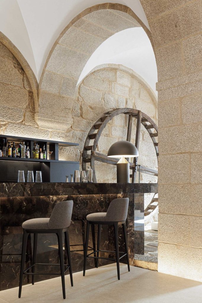 Dark stone bar counter beside a historic wooden wheel