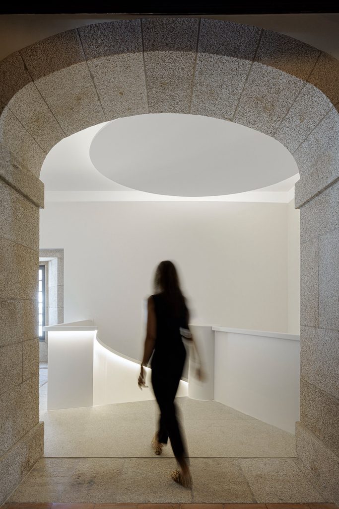 Stone doorway framing a white spiral staircase